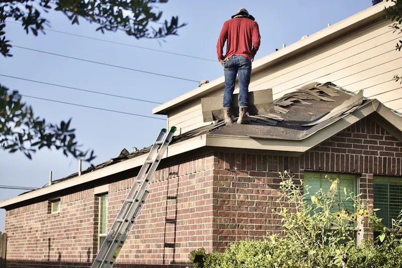 Professional roofer working on a residential roof in The Mermont